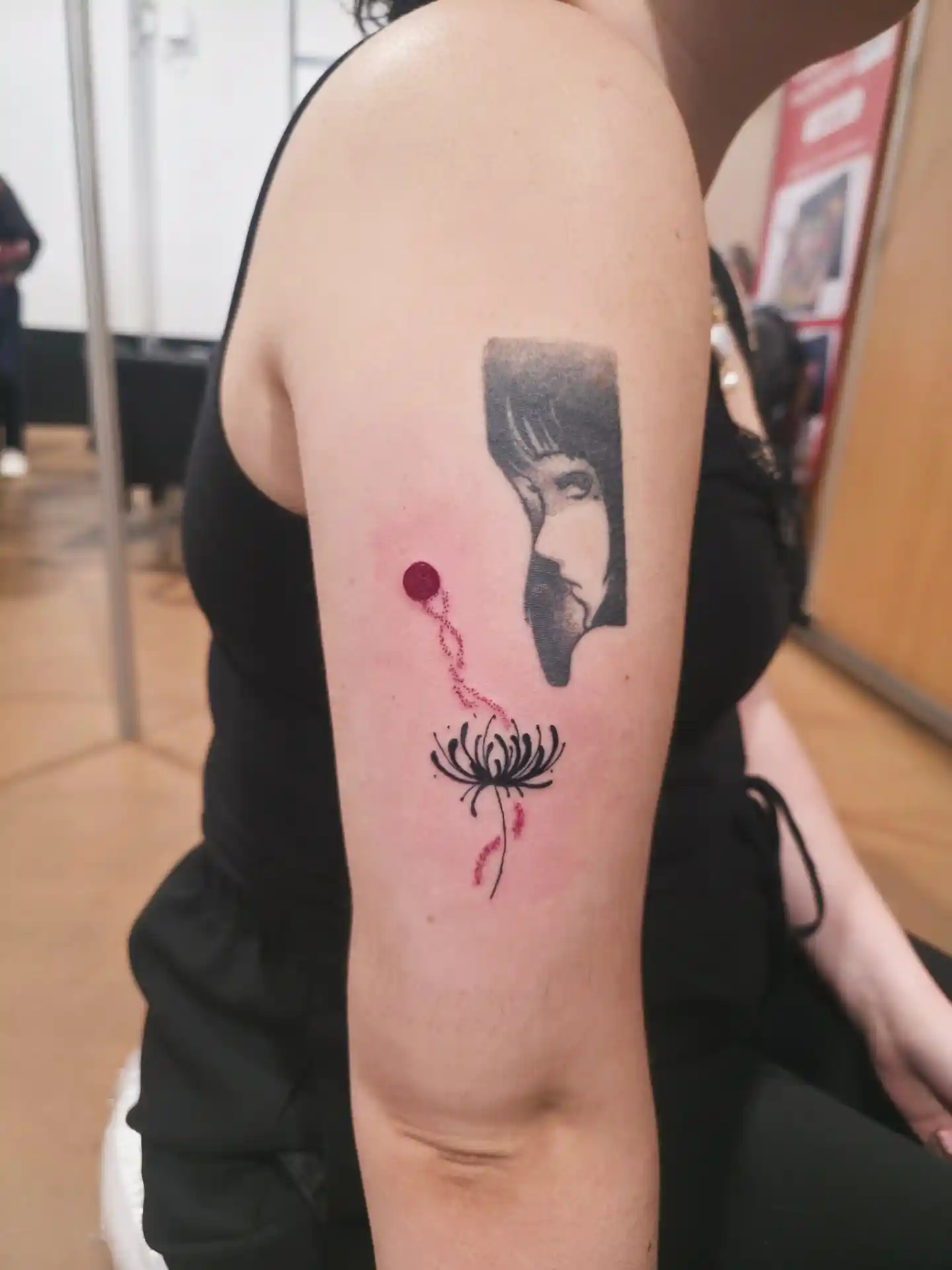 Tatouage fleur rose avec visage stylisé - fine line et touches colorées