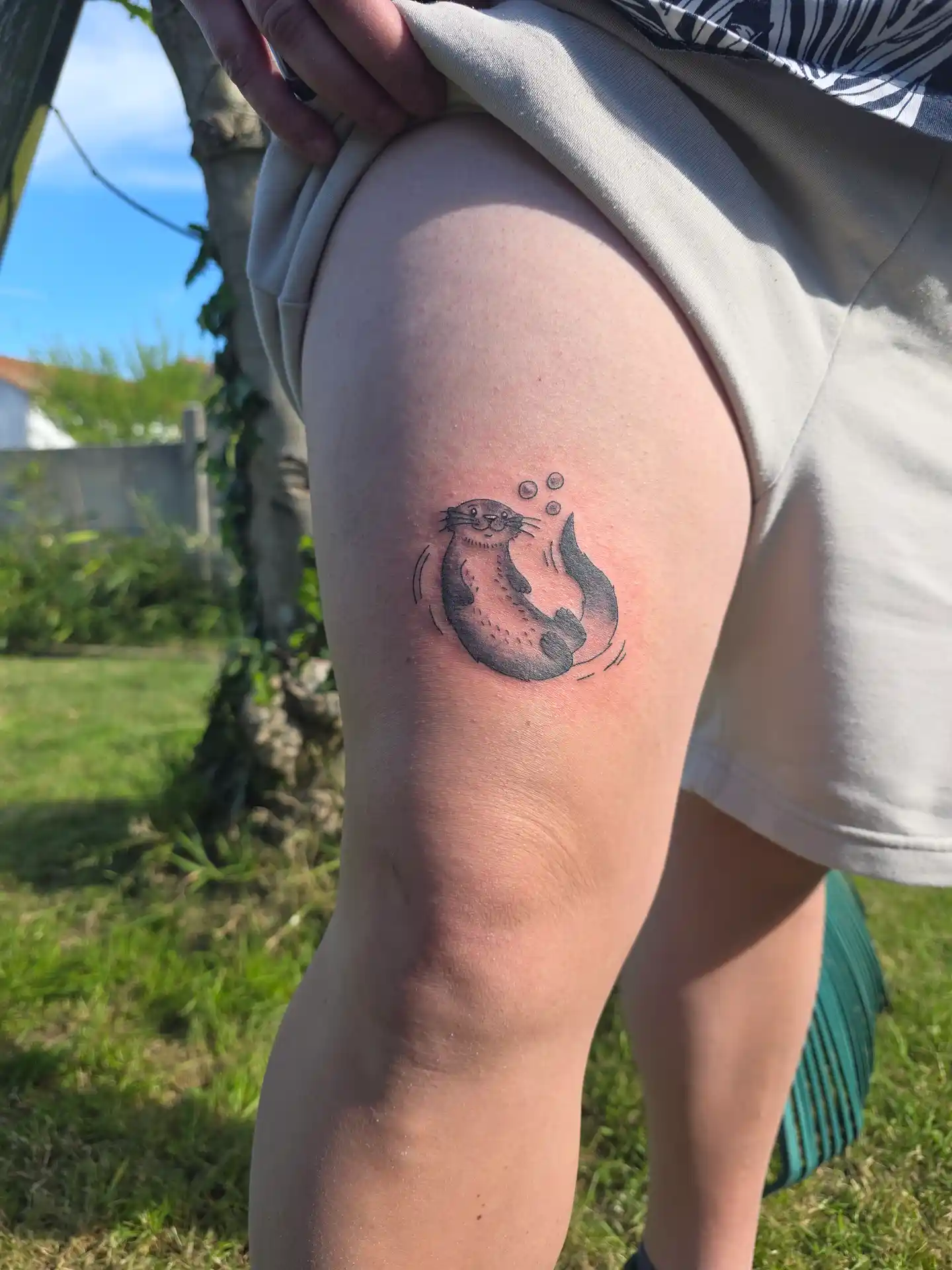 Tatouage loutre réaliste gris avec bulles - style cute et détaillé