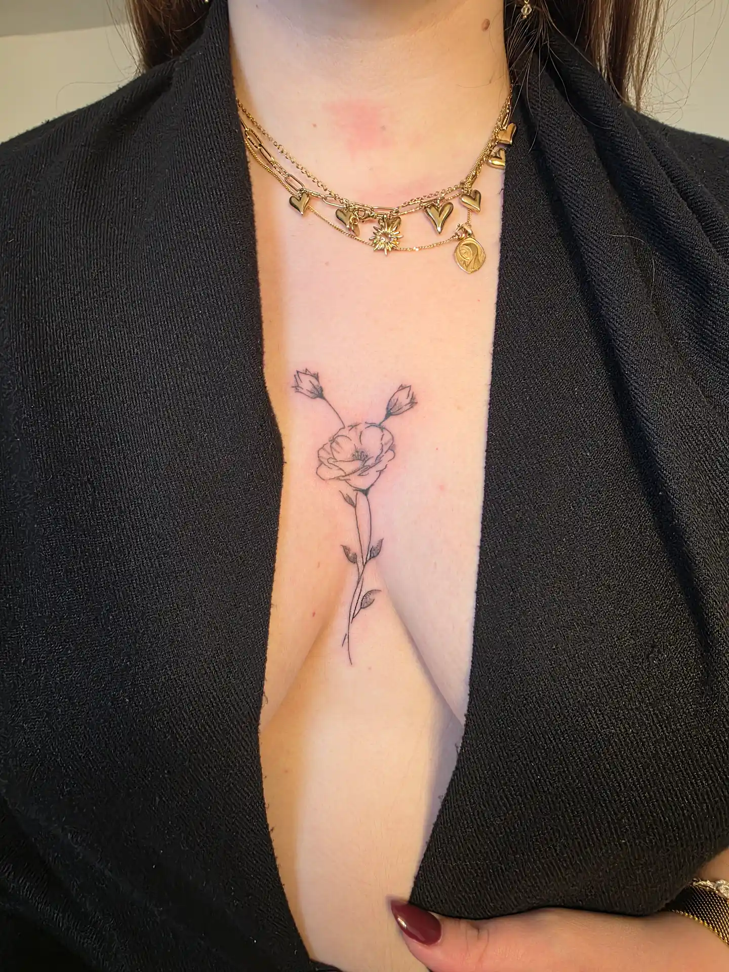 Tatouage rose fine line sous la poitrine - fleur avec détails botaniques